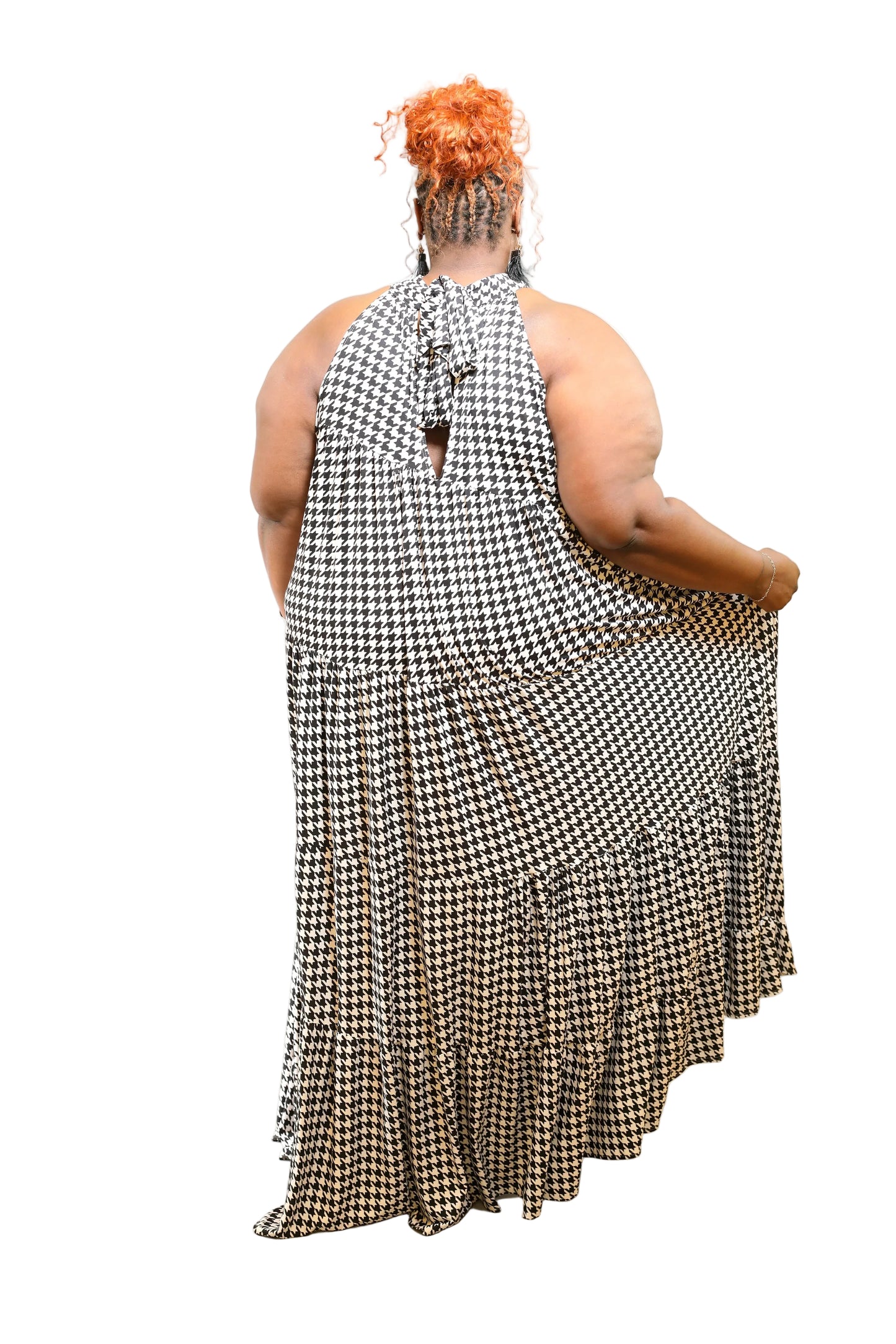 Person wearing a black and white checkered dress on a plain background