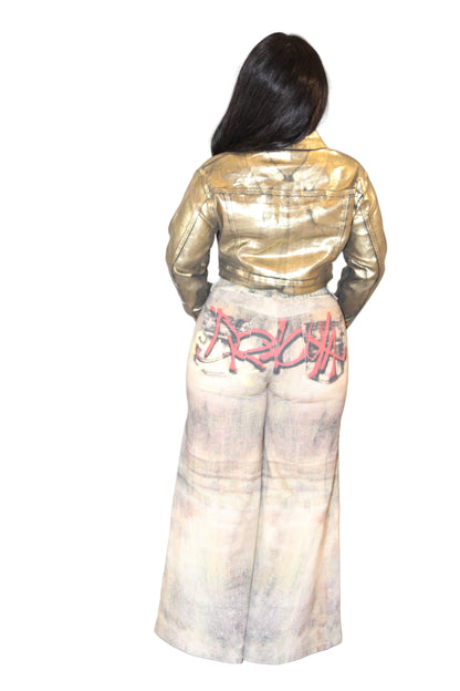Person wearing a gold jacket and white pants with red text on a plain background