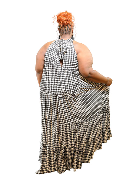 Person wearing a black and white checkered dress on a plain background