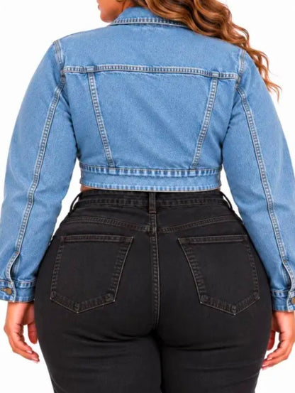 A woman shown from the back wearing a cropped light blue denim jacket and black jeans against a plain white background.