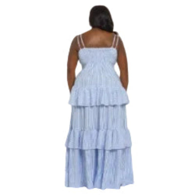 Woman wearing a blue and white striped dress with ruffled layers on a white background (back)