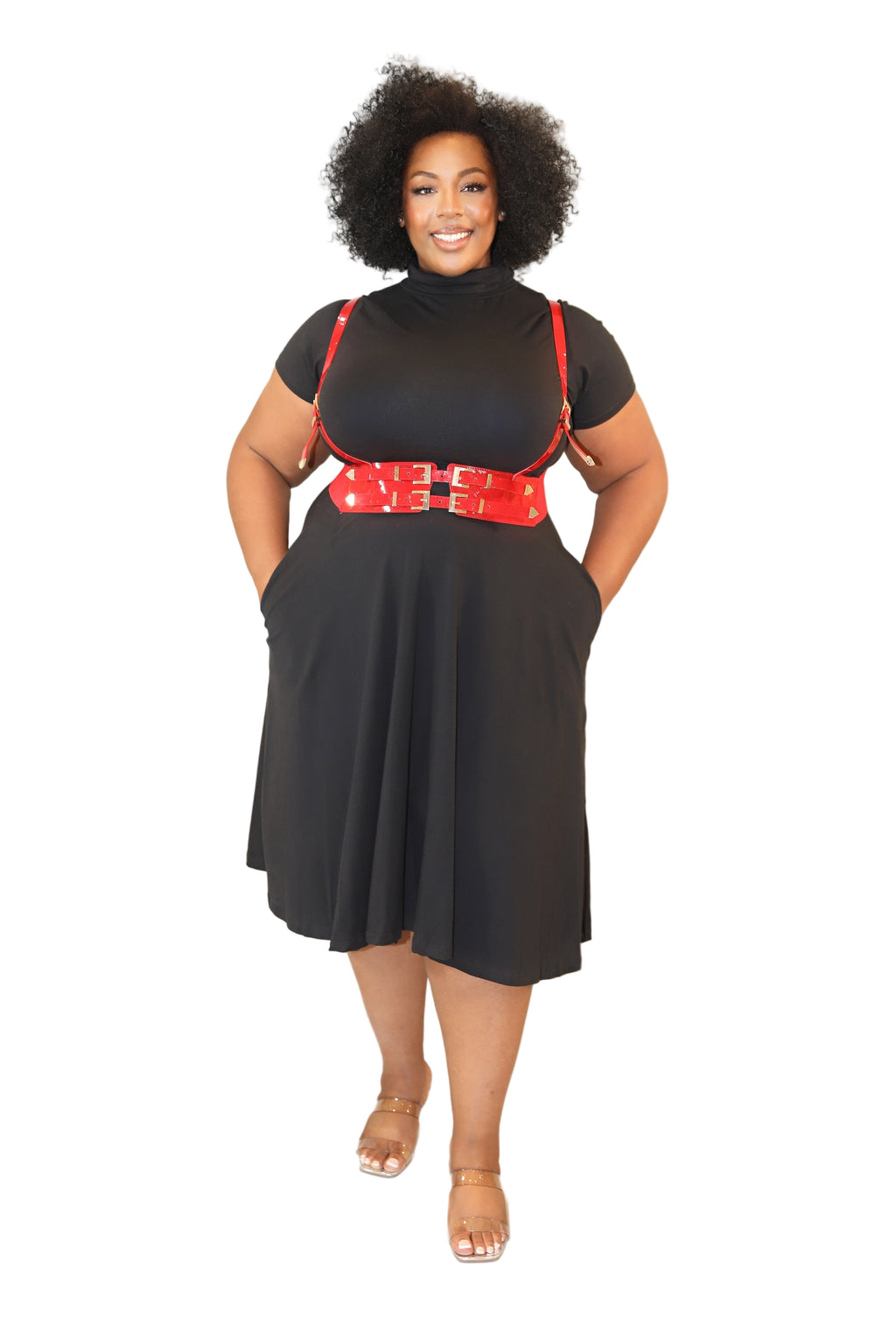 Woman wearing a black dress with red accents against a plain background