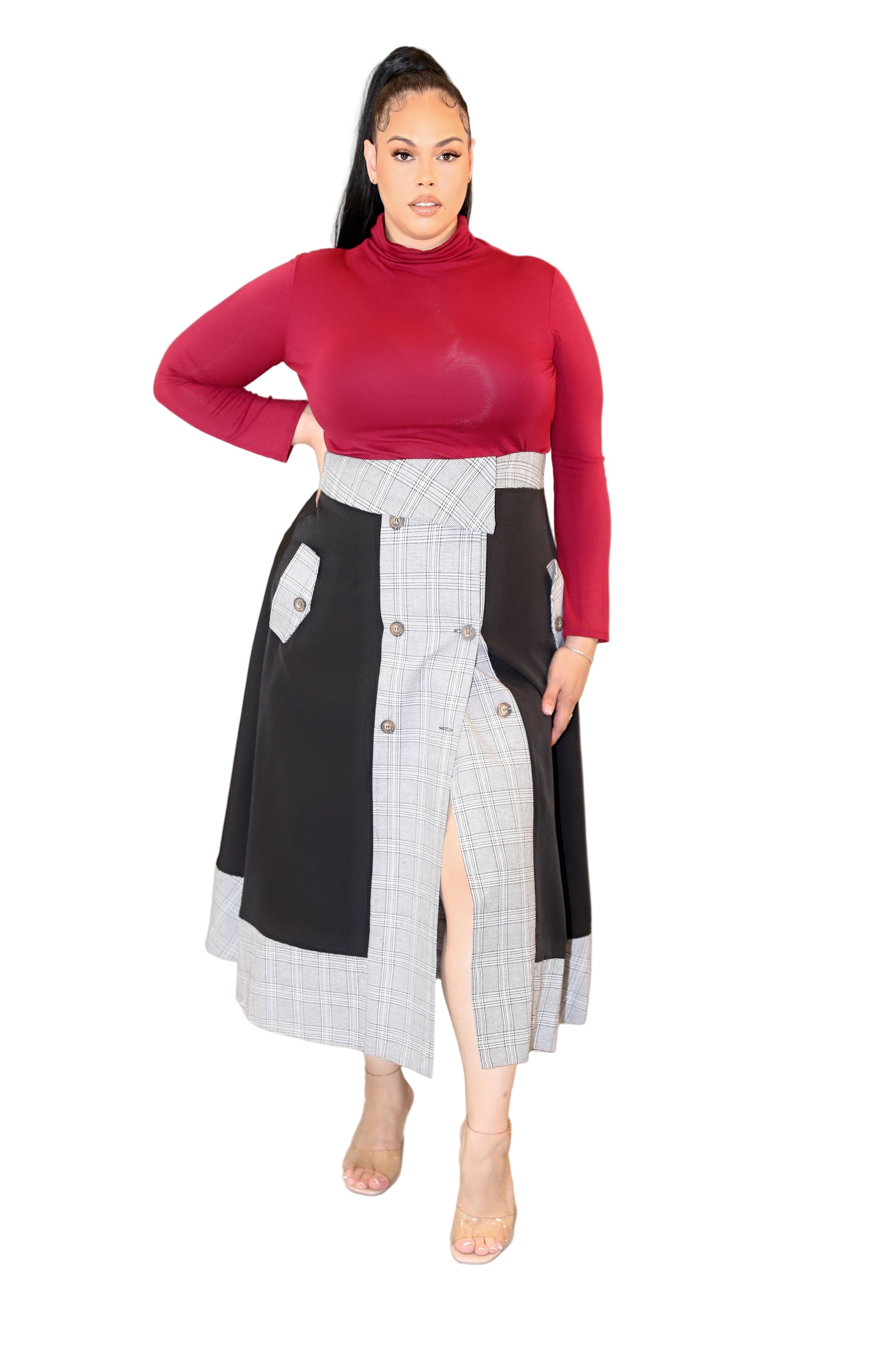 Woman wearing a red top and a black and white skirt on a plain background