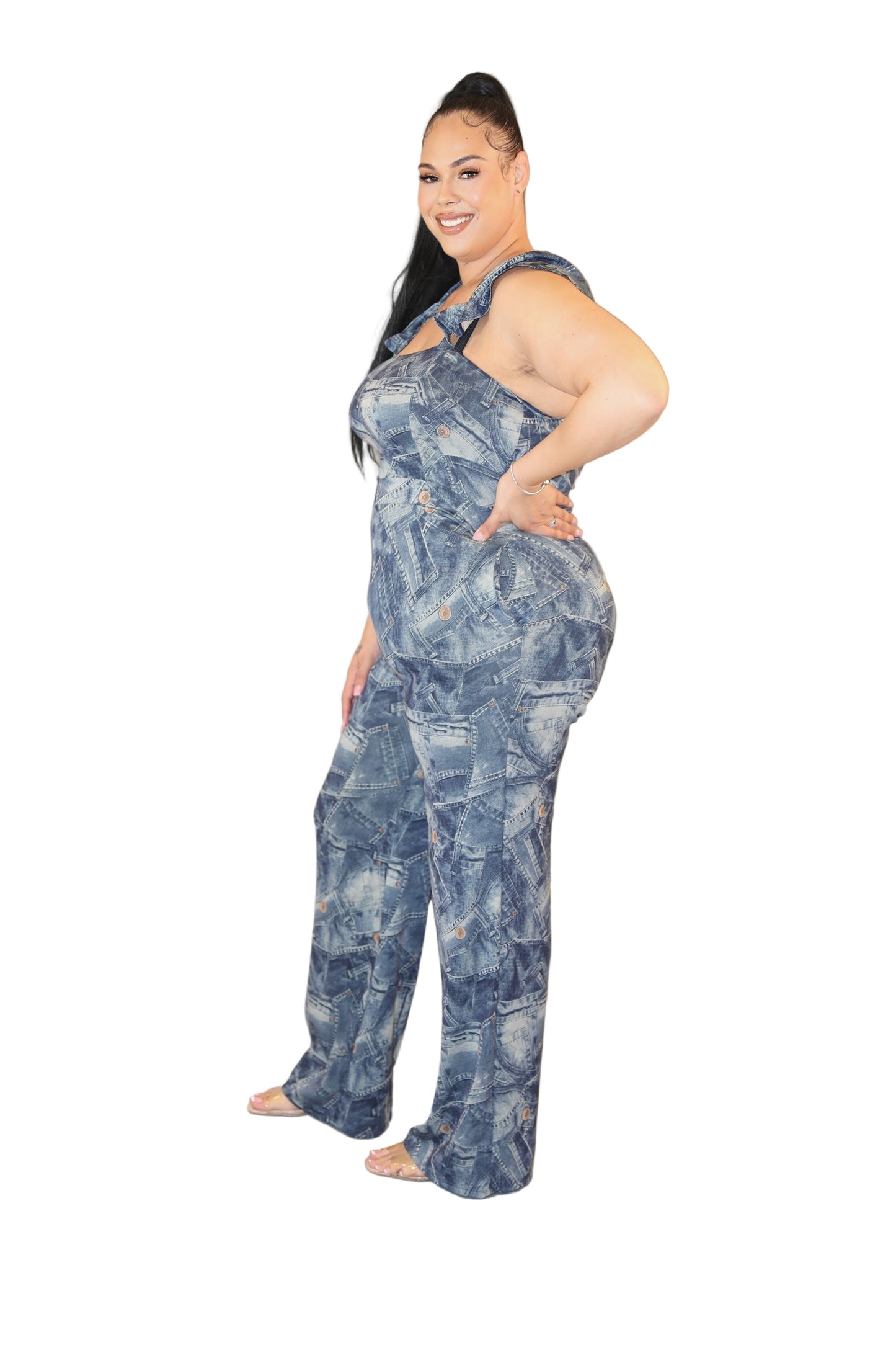 Woman wearing a blue denim jumpsuit on a plain background