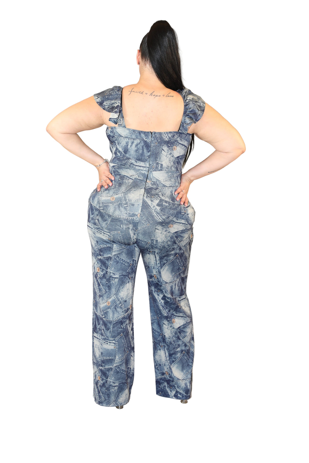 Person wearing a blue patterned jumpsuit against a plain background