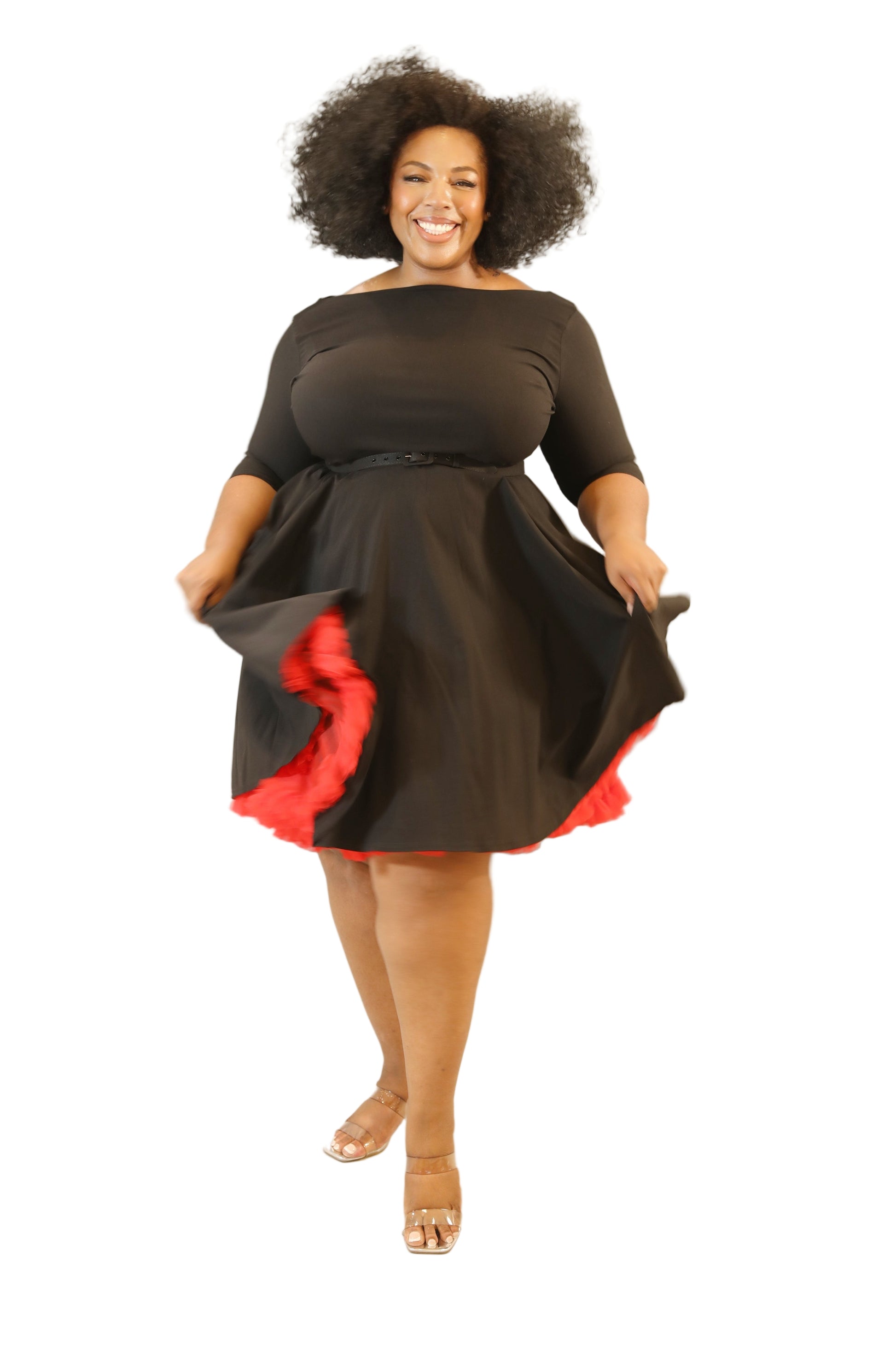 Woman wearing a black dress with red accents on a plain background