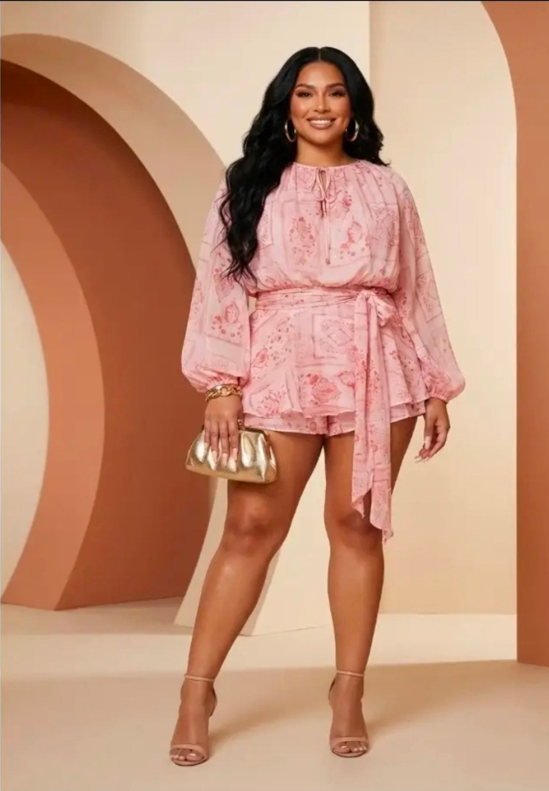 Woman wearing a pink romper against a beige background (front)