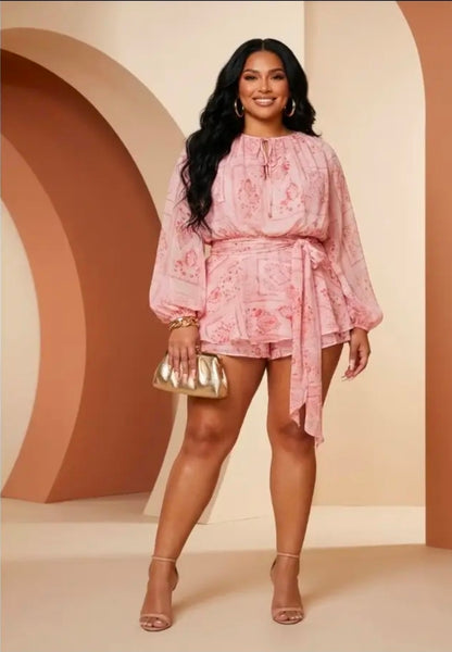 Woman wearing a pink romper against a beige background (front)