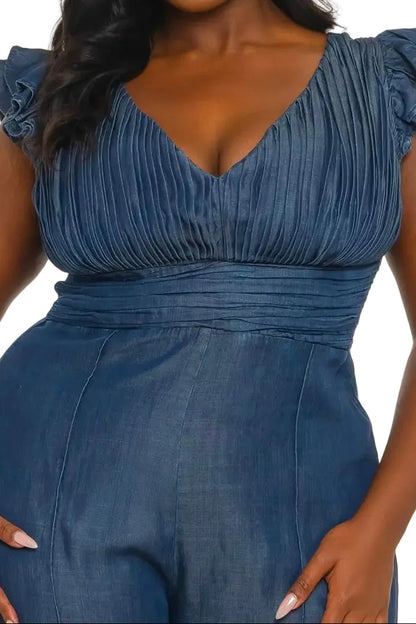 Woman wearing a denim jumpsuit on a white background. (front, close up)