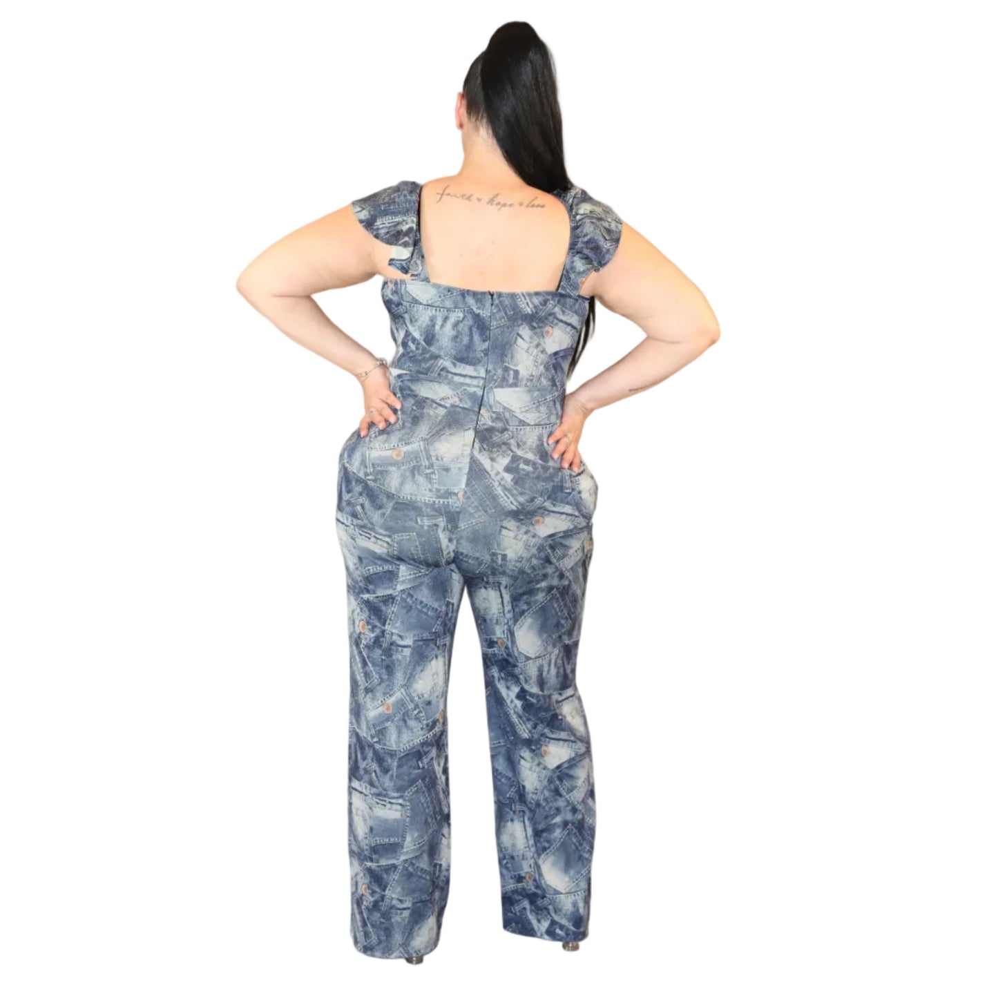 Woman wearing a jumpsuit with a collaged denim print on a white background  with her hands on her hips (back)