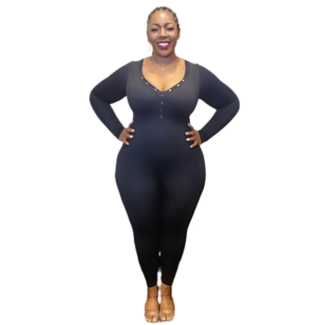 Woman wearing a black long-sleeve catsuit with a v-neck with snaps on a white background.