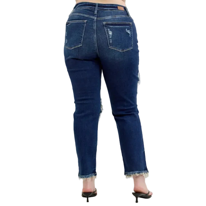 Woman wearing distressed dark wash blue jeans on a white background (back)