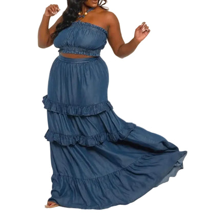 Woman wearing a blue denim bandeau and skirt set with ruffled layers on a white background