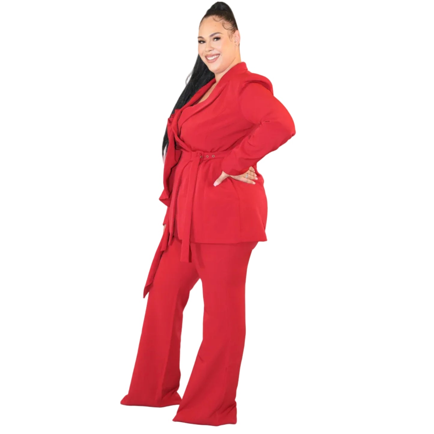 Woman wearing a red suit against a plain background with her hand on her hip (side)