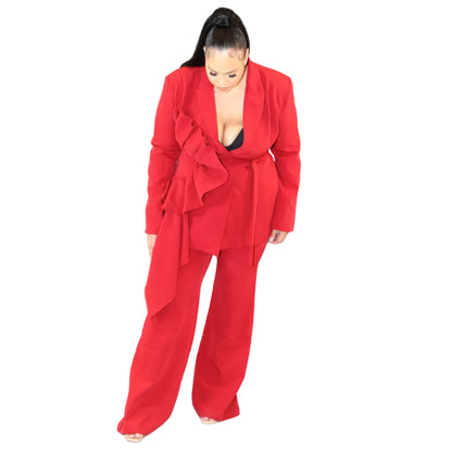 Woman wearing a red suit against a plain background looking down (front)