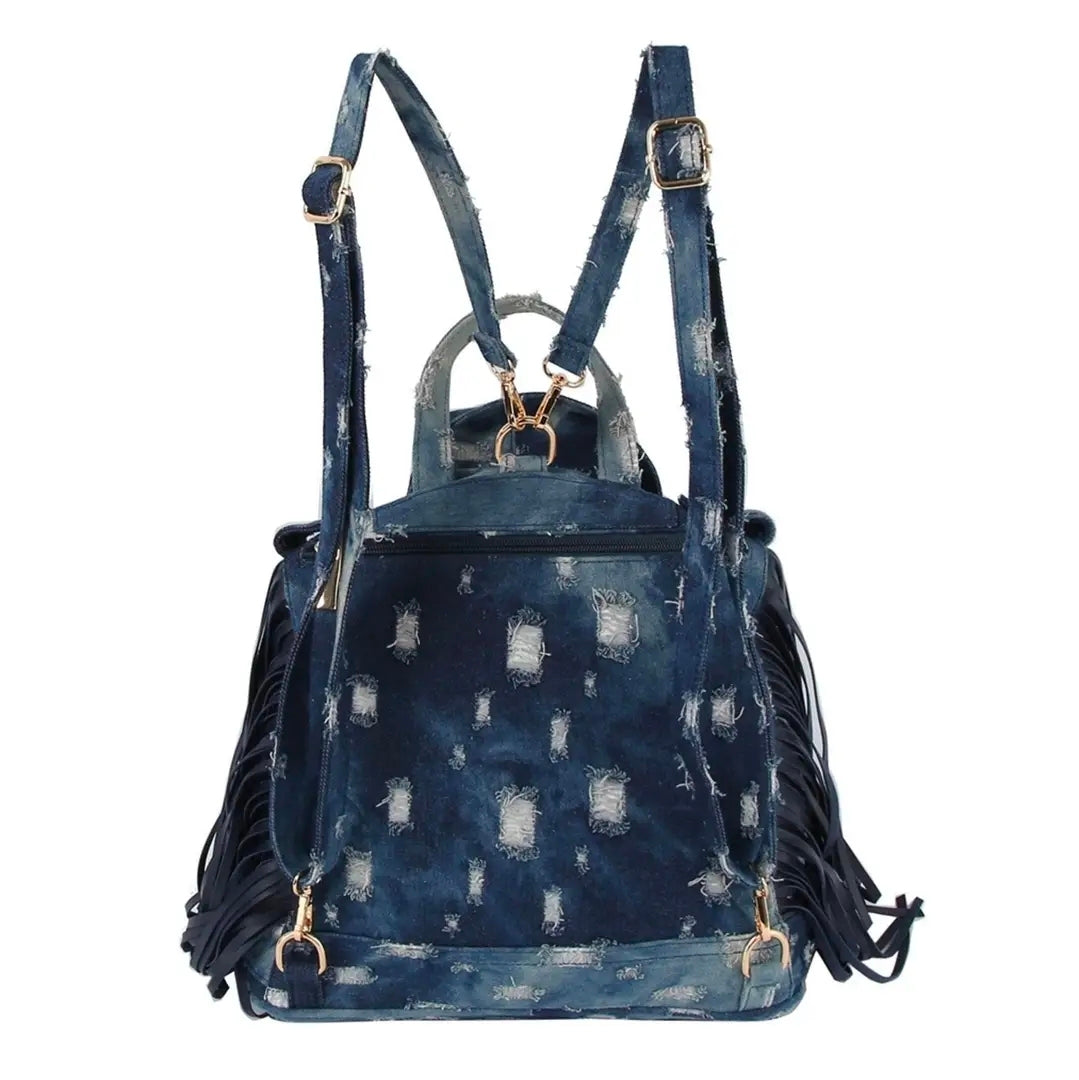 Dark blue denim bag with backpack straps, a handle, fringe, and gold hardware on a white background. (back)