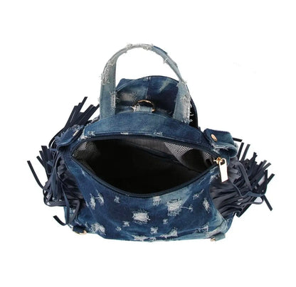Dark blue denim bag with backpack straps, a handle, fringe, and gold hardware on a white background. (inside)