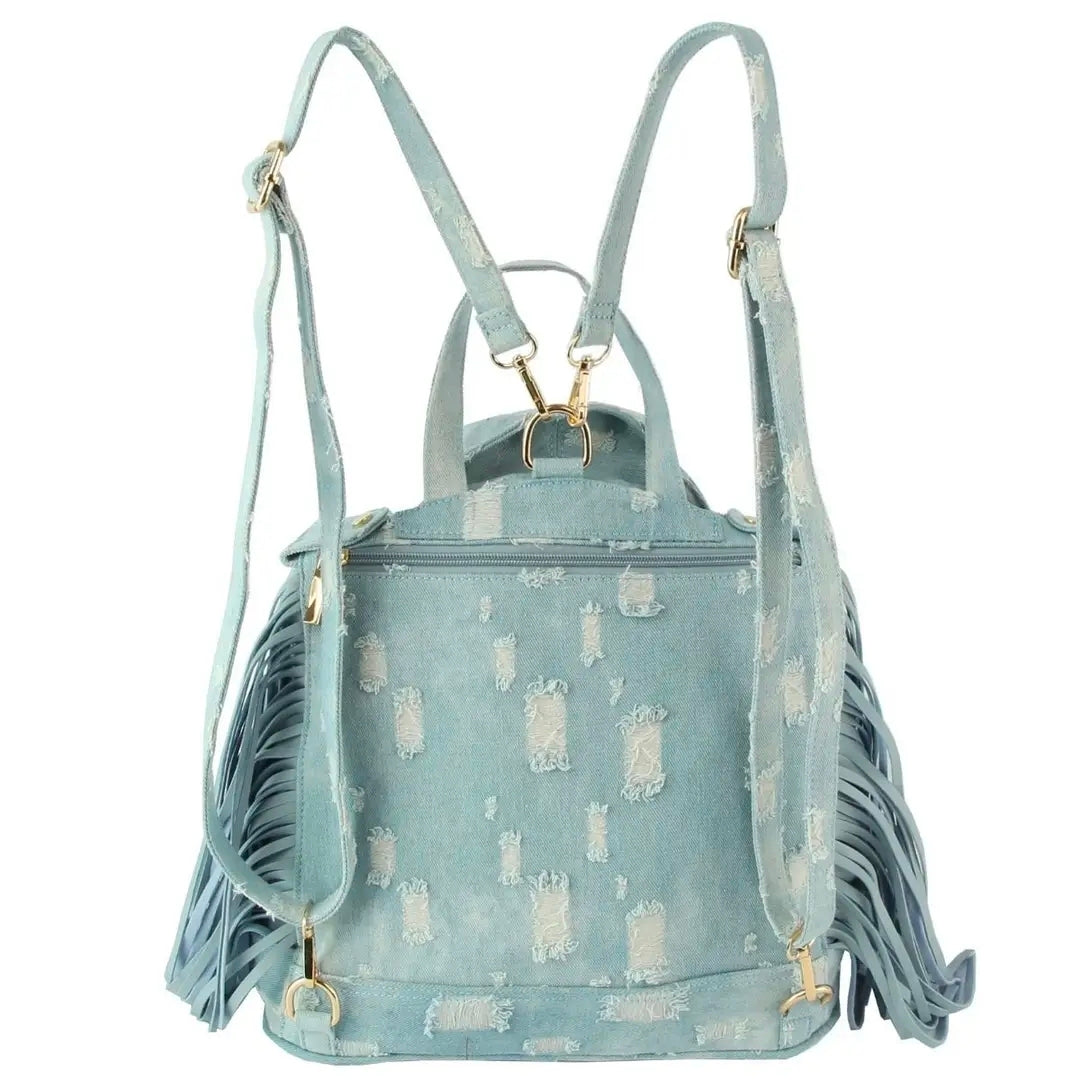 Light blue denim bag with backpack straps, a handle, fringe, and gold hardware on a white background. (back)