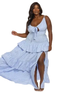Woman wearing a blue and white striped dress with ruffled layers on a white background