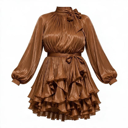 Bronze mini dress with a high neck, large bow at the collar, long balloon sleeves, a matching waist tie, and a tiered ruffled skirt, shown on a plain white background.